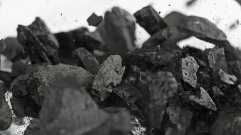 Super Slow Motion Shot of Coal and Black Powder Falling on White Background at 1000 fps.