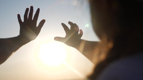 hands in the sun. mom and daughter hands reach out to the sun silhouette sunlight. happy family kid dream concept. mom and daughter dream of god sunset religion concept
