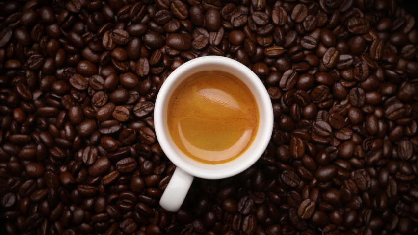 Cup of coffee with fresh roasted coffee beans background (seamless looping) | Shutterstock HD Video #1063975759