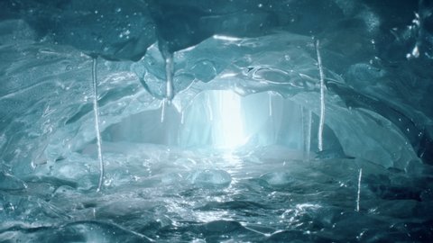 Inside an amazing ice cave with icicles and beautiful light. Turquise and blue frosty ice cave in 4k.