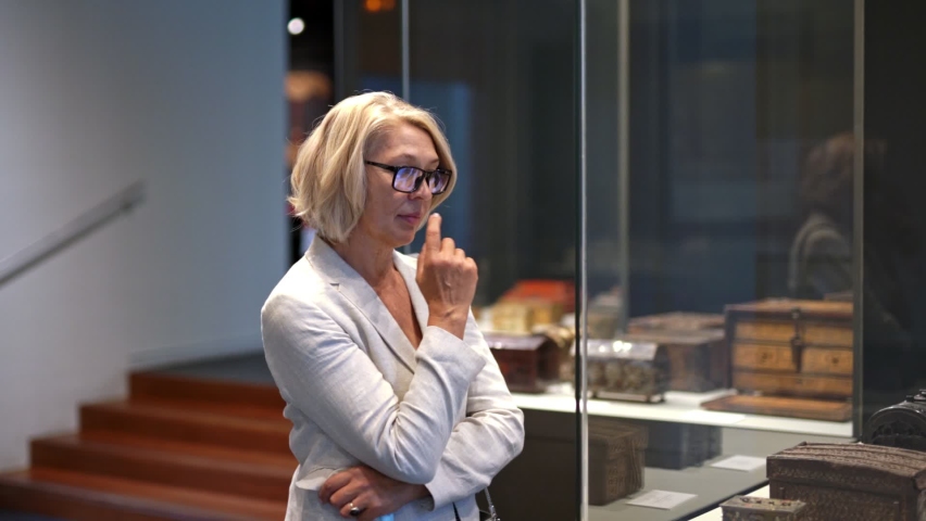 Woman visitor in historical museum looking at art object | Shutterstock HD Video #1063991056