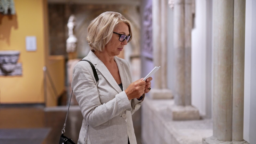 woman visitor in historical museum looking at art object
