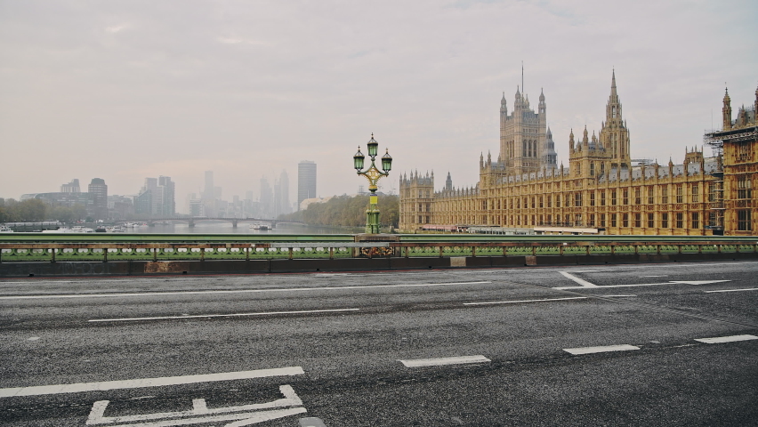 Empty road in London in Coronavirus Covid-19 lockdown with no traffic in quiet streets and one person cycling by bicycle on their bike to commute in England, UK | Shutterstock HD Video #1063991704