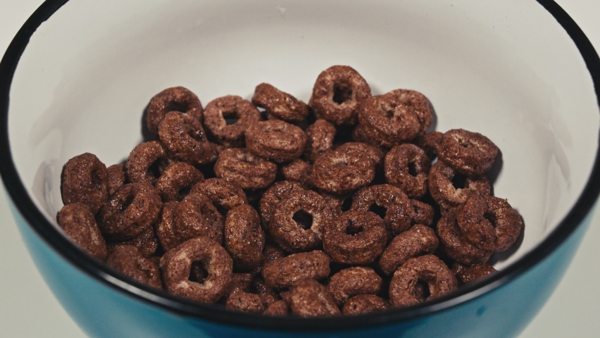 Milk being poured over breakfast cereal hoops. Top view