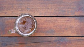 Top view 4k video of jug of beer isolated on brown vintage wooden surface background