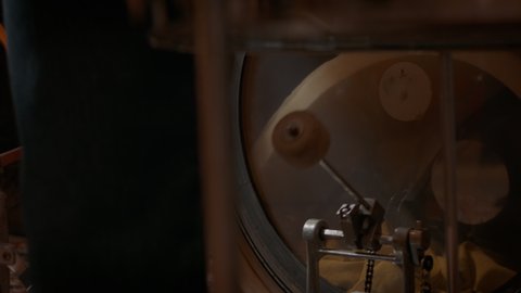 LOW ANGLE view of male playing drums with his band, CU on kick pedal. Shot with 2x Anamorphic lens