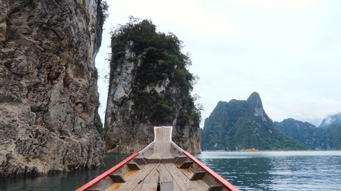 Amazing View from Long Tail Boat of Beautiful Limestone Mountains and Tropical Rain Forest Trees at Cheow Lan Lake in Khao Sok National Park in Thailand. Vacation at Famous Touristic Place