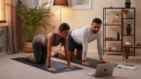 Young Caucasian Man And Woman Couple In Sportswear Doing Sports At Home On Mat While Watching Fitness Video Online On Laptop. Stay Home Quarantine Workout Training, Workout And Wellness Concept