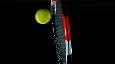 Super Slow Motion of Tennis Racket Hitting a Ball on Black Background