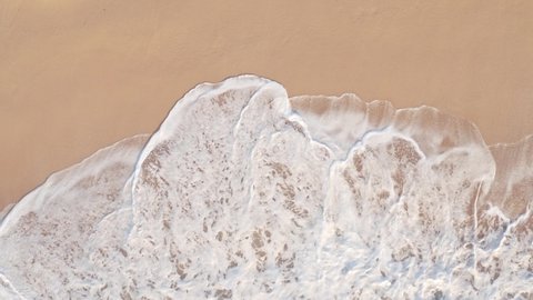 Close up of ocean waves rolling onto a beautiful beach at sunrise