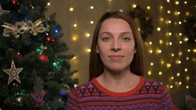 Woman making x-mas eve video meeting conference congratulating relatives family remotely, sit at home near twinkled lights decorated Christmas tree, modern tech concept