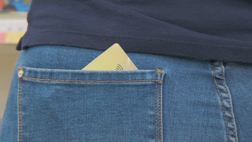 Woman has contactless credit card in her pocket. Fraudsters brings device and reads information card account. Concept hacking and information security