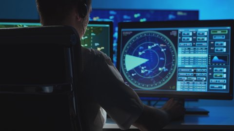 Workplace of the professional air traffic controller in the control tower. Caucasian aircraft control officer works using radar, computer navigation and digital maps.