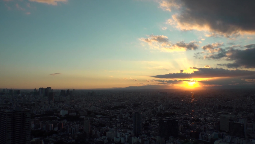 TOKYO, JAPAN : Aerial high angle sunrise CITYSCAPE of TOKYO. View of buildings around Shinjuku and Nakano ward. Japanese urban metropolis and nature concept. Time lapse zoom out shot night to morning.
