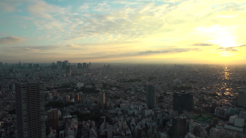TOKYO, JAPAN : Aerial high angle sunrise CITYSCAPE of TOKYO. View of buildings around Shinjuku and Nakano ward. Japanese urban metropolis and nature concept. Time lapse zoom out shot night to morning.