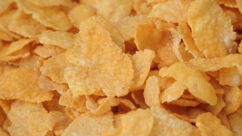 Golden dry cornflakes super close up slowly rotating stock footage