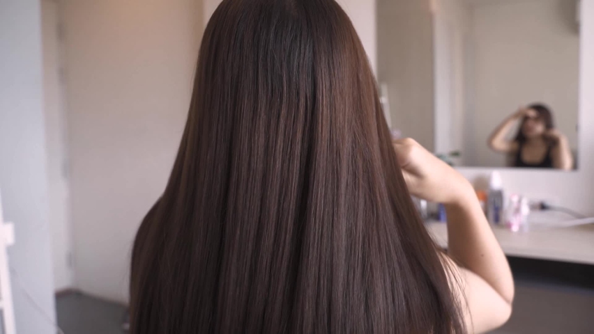 A long haired woman combing her hair and beautiful hair care.