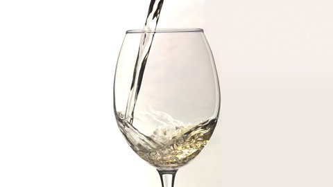 Young white wine pouring into wine glass close up slow motion isolated white background