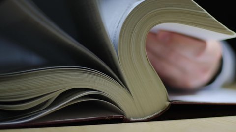 Male hand flipping through the pages of a book, closeup