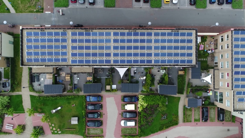 Aerial top down view of new built apartment complex with solar panels installed on the roof from which the photo voltaic cells use sunlight as a source of energy and generate electricity 4k quality Royalty-Free Stock Footage #1064045995