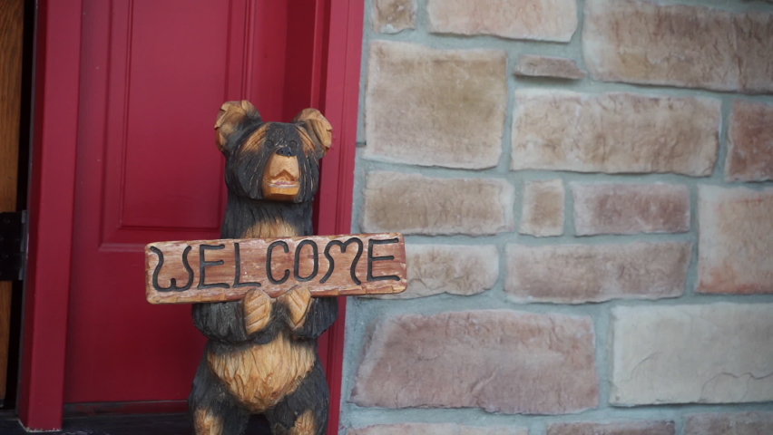 CU Wooden bear with welcome sign in front of door