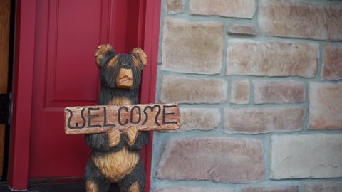 CU Wooden bear with welcome sign in front of door