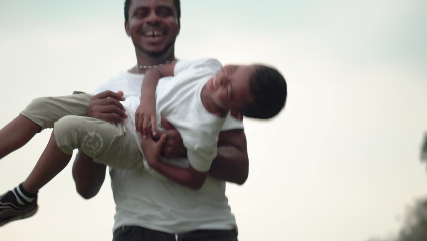 Cheerful african american father and son playing in park, Happiness family concepts, parent and child play in park