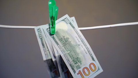 business success. man takes off paper hundred dollar bills hanging on a rope. close-up. shallow depth of field