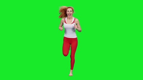 Slim smiling sporty fitness woman with beautiful smile jogging against green screen background, chroma key 4k pre-keyed footage