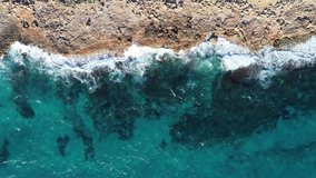 Aerial view of a beach with blue water and waves at the golden hour with space for a text or title, background static shot. Mediterranean. Mallorca