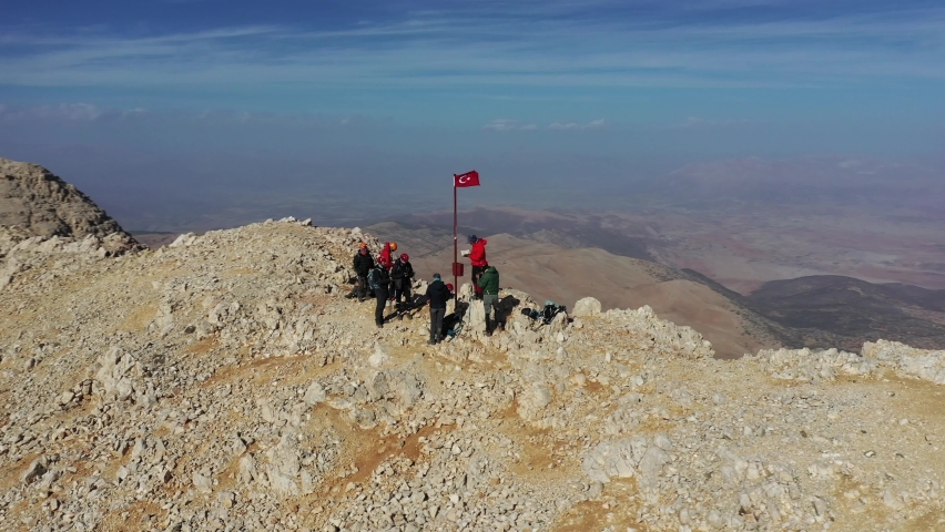 Aerial footage around peak of rocky mountain. 