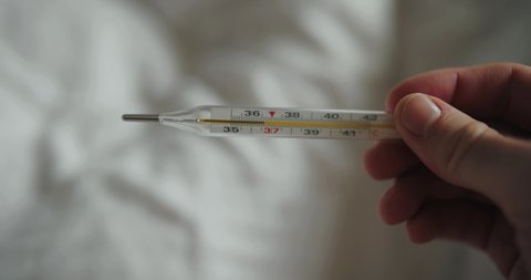 Mercury thermometer shows 36.6 temperature in a male hand