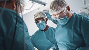 Diverse surgical corporate staff perform operation with chief surgeon doctor in hospital operating room. Collaboration. Surgery concept. - Powered by Shutterstock - Get 15% off with code: PIKWIZARD15
