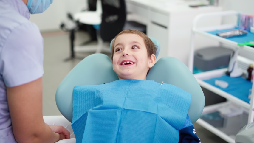 Woman Doctor in a Dental Clinic Talking with Funny Little Boy who Smiles. Work of a Dentist with Children. Healthcare and Medicine Concept. High quality 4k footage | Shutterstock HD Video #1064080315
