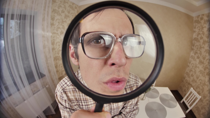Nerd looks through magnifier glass | Shutterstock HD Video #1064090974