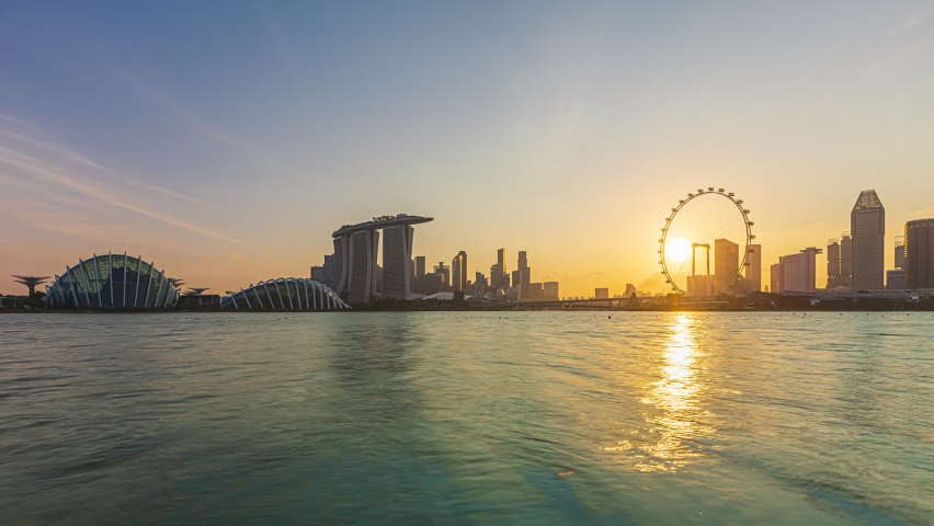 Beautiful Time lapse of Day to Night of Singapore skyline from afar by a river. Prores. Zoom in motion timelapse. Prores Full HD. 4K available. Royalty-Free Stock Footage #1064096557