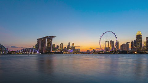 Beautiful Time lapse of Day to Night of Singapore skyline from afar by a river. Prores. Zoom in motion timelapse. Prores Full HD. 4K available.