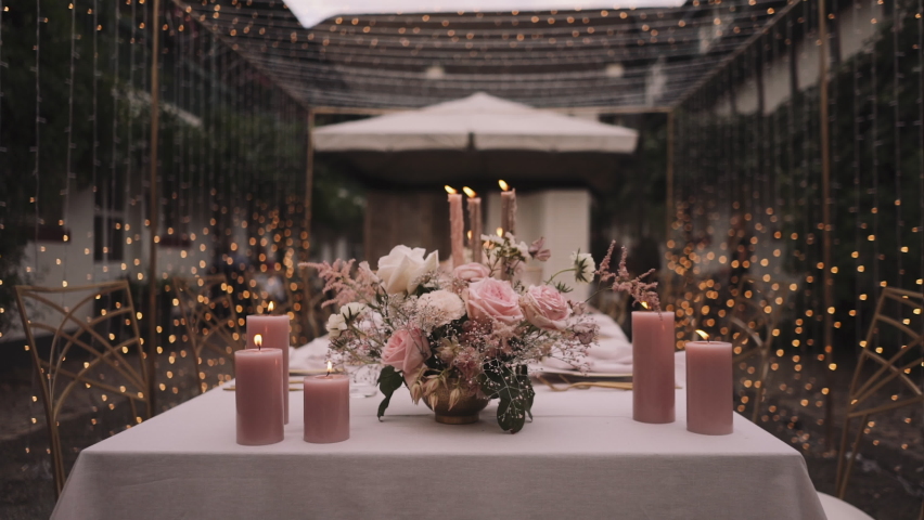 Festive table decor. In pastel pink colors with golden cutlery. With different natural colors roses, peonies, anthurium. Luxury wedding, party, birthday.  Royalty-Free Stock Footage #1064099611