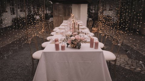 Festive table decor. In pastel pink colors with golden cutlery. With different natural colors roses, peonies, anthurium. Luxury wedding, party, birthday. 