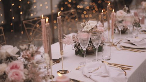 Festive table decor. In pastel pink colors with golden cutlery. With different natural colors roses, peonies, anthurium. Luxury wedding, party, birthday. 
