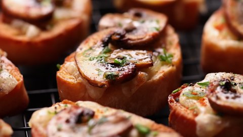 Close up view on mushroom and cheese crostini sprinkled with salt flakes. Delicious appetizers Stockvideó
