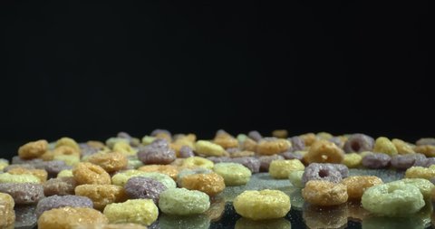 Colorful Cereal Hoops on the glossy surface slide shot. Zoom in. High quality 4k footage