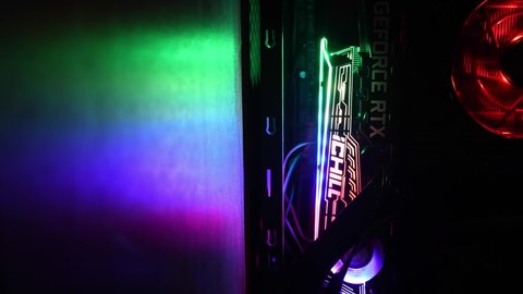 Vertical format video with blurred focus foreground. Gaming PC tower with NVidia GeForce RTX 3080 graphics card and blinking colorful backlight of rotating cooling fans. Odessa, Ukraine, 12 13 2020