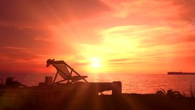 Empty deck chair on a background of orange sunset. 3d render