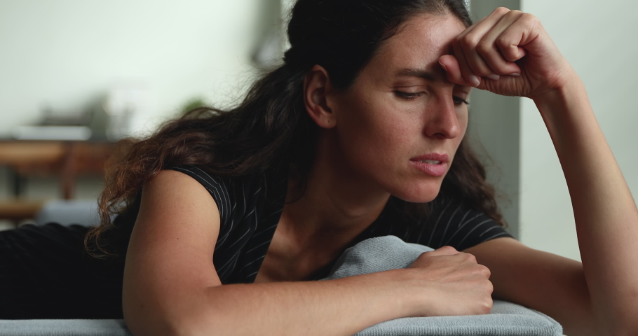 Close up sad stressed young unhappy female lying on couch indoor experiencing personal problems worries due break up, divorce or cheating feels miserable or guilty at home alone. Life troubles concept | Shutterstock HD Video #1064112490