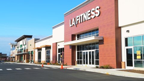 Herndon, USA - March 18, 2020: LA Fitness membership gym store with outdoors outside facade view on shopping strip mall in Northern Virginia