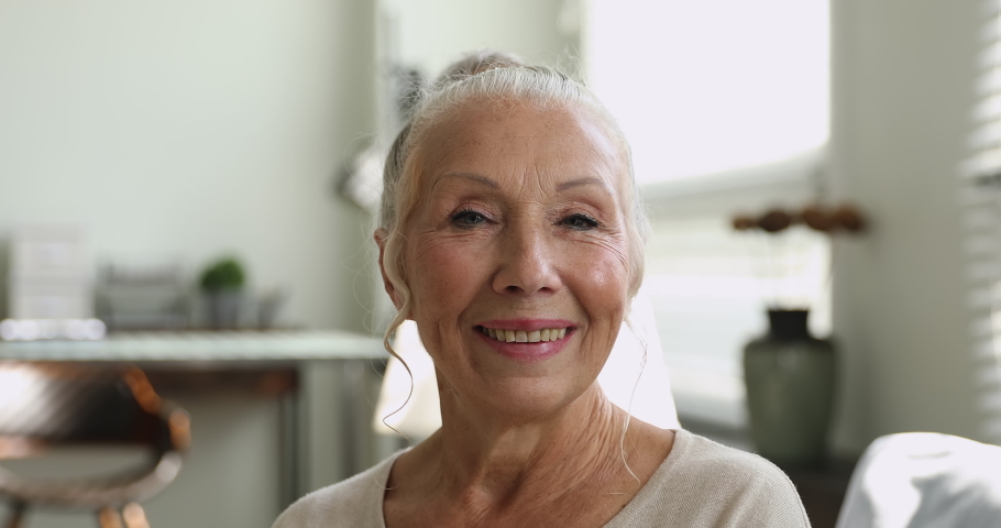 Close up wrinkled face of 65s happy elderly woman look at camera having wide smile, dental implants and prostheses satisfied client portrait, medical insurance for older people, natural beauty concept Royalty-Free Stock Footage #1064113009