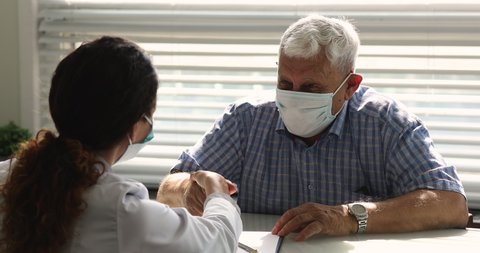 Doctor explain test results, agreement terms shaking hands with older patient, people in face masks due corona virus pandemic outbreak. Senile disease treatment, medical insurance for seniors concept