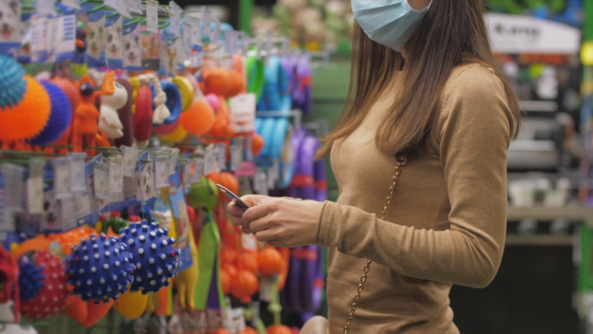 Professional shopper looks at blue animal ball on shelf with wide range of animal toys in department store. Concept shopaholic | Shutterstock HD Video #1064116741