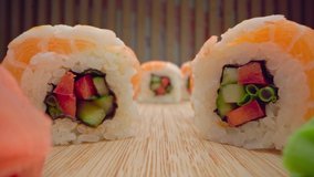 Zoom in slide video of japanese sushi roll on wooden background